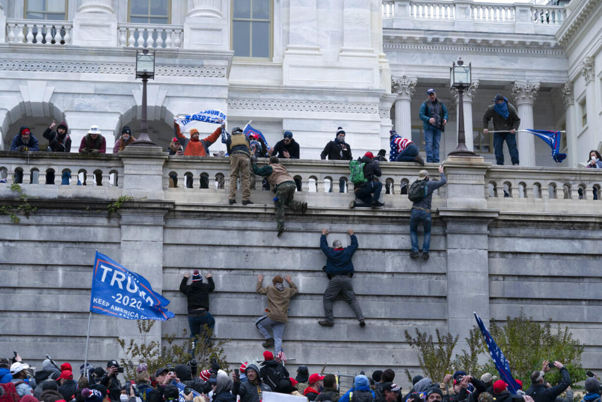 Supporters of President Donald Trump climb the west wall of the the U.S. Capitol on Wednesday, Jan. 6, 2021, in Washington.