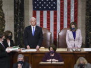 Vice President Mike Pence and Speaker of the House Nancy Pelosi, D-Calif., read the final certification of Electoral College votes cast in November's presidential election during a joint session of Congress after working through the night, at the Capitol in Washington, Thursday, Jan. 7, 2021. Violent protesters loyal to President Donald Trump stormed the Capitol Wednesday, disrupting the process. (AP Photo/J.