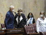 State Sen. Reuven Carlyle, left, D-Seattle, votes in favor of adopting new Senate rules as other senators, who had to come to the floor from the gallery and nearby offices, wait near him to cast their own votes, Monday, Jan. 11, 2021, at the Capitol in Olympia. At right is Sen. Annette Cleveland, D-Vancouver. (AP Photo/Ted S.