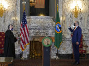 Washington Gov. Jay Inslee, right, takes the oath of office for his third term as Governor, as administered by Washington Supreme Court Chief Justice Steven Gonzalez, left, Wednesday, Jan. 13, 2021, during a ceremony at the Capitol in Olympia, Wash. (AP Photo/Ted S.