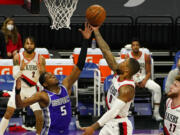 Portland Trail Blazers guard Damian Lillard, right, goes to the basket against Sacramento Kings guard De'Aaron Fox, left, during the first quarter of an NBA basketball game in Sacramento, Calif., Wednesday, Jan. 13, 2021.