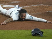 Seattle Mariners shortstop J.P. Crawford sprawls on the dirt and reacts after sliding safely home during the fifth inning of a baseball game against the Houston Astros, Wednesday, Sept. 23, 2020, in Seattle. Crawford scored on a double hit by Kyle Seager. (AP Photo/Ted S.