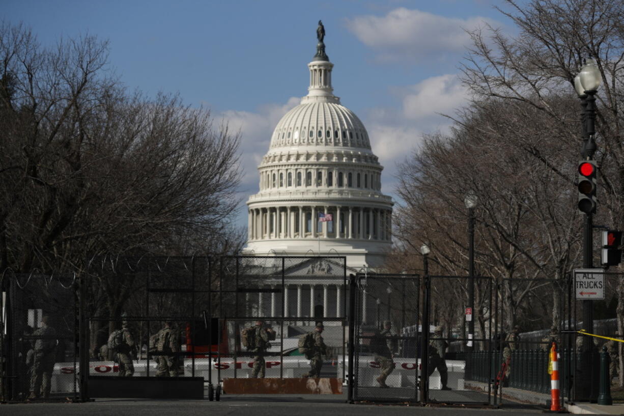 National Guard troops walk outside the Capitol as the security perimeter continues to shrink and many Guard units head home, two days after the inauguration of President Joe Biden on Friday, Jan.