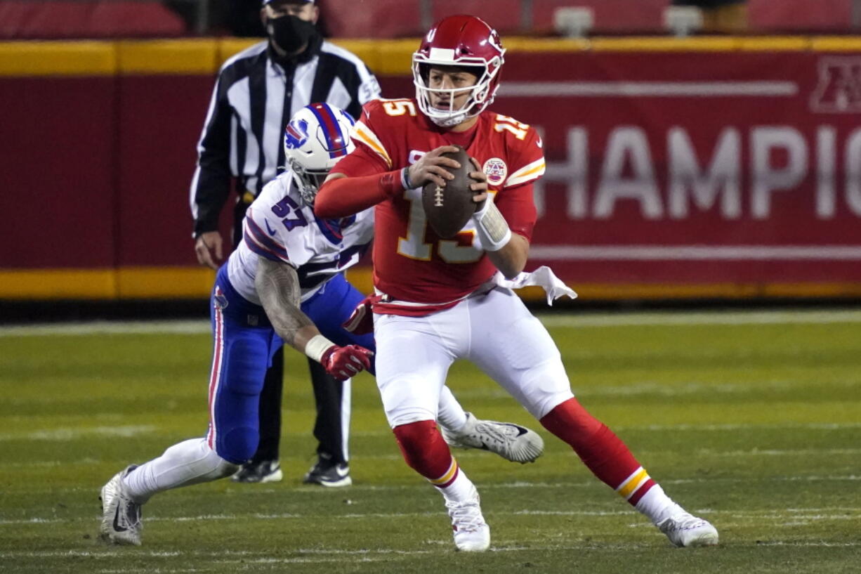 Kansas City Chiefs quarterback Patrick Mahomes (15) scrambles up field ahead of Buffalo Bills defensive end AJ Epenesa (57) during the first half of the AFC championship NFL football game, Sunday, Jan. 24, 2021, in Kansas City, Mo.