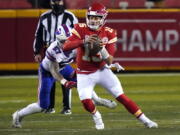 Kansas City Chiefs quarterback Patrick Mahomes (15) scrambles up field ahead of Buffalo Bills defensive end AJ Epenesa (57) during the first half of the AFC championship NFL football game, Sunday, Jan. 24, 2021, in Kansas City, Mo.