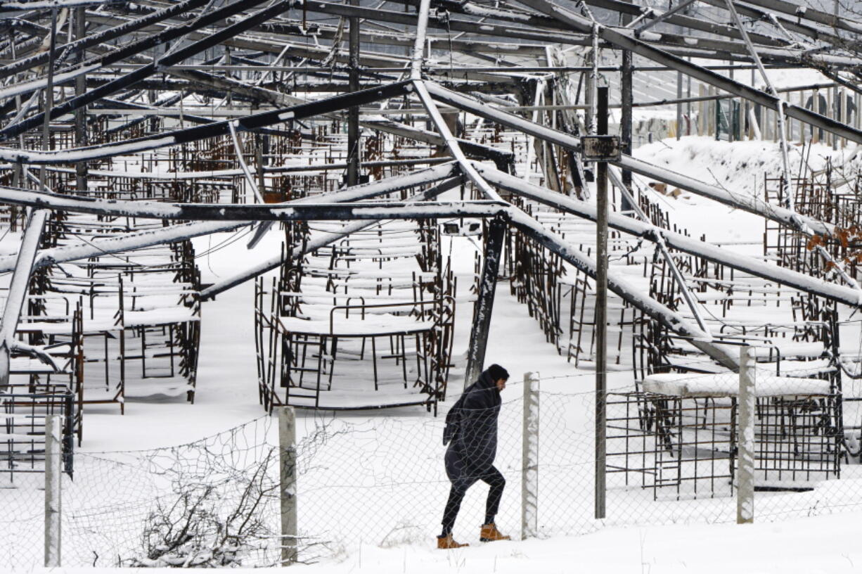 A migrant walks during a snowfall at the Lipa camp, outside Bihac, Bosnia, Monday, Jan. 11, 2021. Aid workers say migrants staying at a camp in northwestern Bosnia have complained or respiratory and skin diseases after spending days in make-shift tents and containers amid freezing weather and snow blizzards. Most of the hundreds of migrants at the Lipa facility near Bosnia&#039;s border with Croatia on Monday have been accommodated in heated military tents following days of uncertainty after a fire gutted most of the camp on Dec. 23.