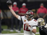 Tampa Bay Buccaneers quarterback Tom Brady (12) works against the New Orleans Saints during the first half of an NFL divisional round playoff football game, Sunday, Jan. 17, 2021, in New Orleans.