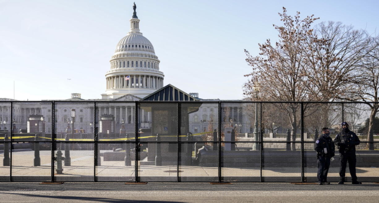 Capitol police officers stand outside of fencing that was installed around the exterior of the Capitol grounds, Thursday, Jan. 7, 2021 in Washington. The House and Senate certified the Democrat&#039;s electoral college win early Thursday after a violent throng of pro-Trump rioters spent hours Wednesday running rampant through the Capitol. A woman was fatally shot, windows were bashed and the mob forced shaken lawmakers and aides to flee the building, shielded by Capitol Police.