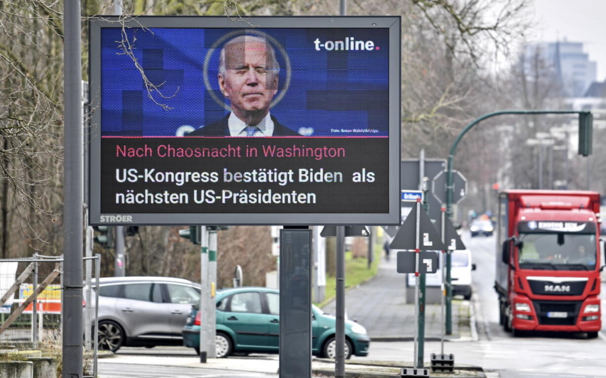 FILE - In this Jan. 7, 2021, file photo, a news screen in Essen, Germany, displays an image of Joe Biden, and a headline reading &#039;After chaos night in Washington, US Congress confirms Biden as next US President. For America&#039;s allies and rivals alike, the chaos unfolding during Donald Trump&#039;s final days as president is the logical result of four years of global instability brought on by the man who promised to change the way the world viewed the United States. By seeking to overturn his loss to Joe Biden, Trump upended the bedrock principle of democratic elections that the United States has sought to export around the world.