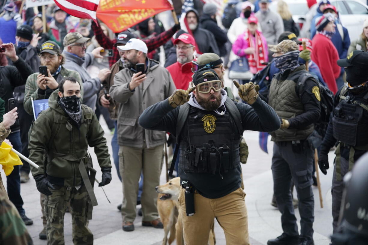 FILE - In this Jan. 6, 2021, file photo, Trump supporters gather outside the Capitol in Washington. As rioters converged on the U.S. Capitol building, the grounds normally hailed as the seat of American democracy became a melting pot of extremist groups. Militia members, white supremacists, paramilitary organizations and fervent supporters of outgoing President Donald Trump stood shoulder to shoulder, unified in rage. Experts say years of increasing partisanship and a growing fascination of paramilitary groups combined with the coronavirus pandemic to create a conveyor belt of radicalization.