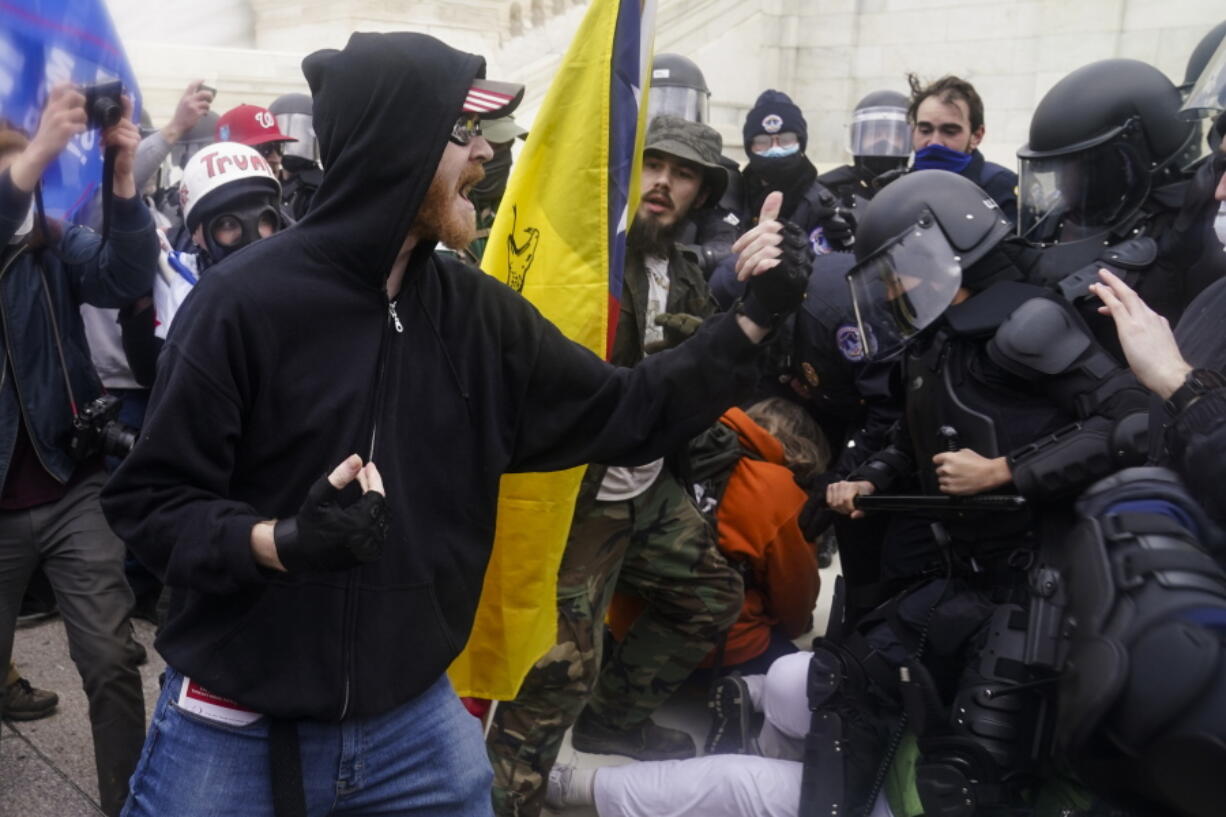 FILE - In this Jan. 6, 2021, file photo, Trump supporters try to break through a police barrier at the Capitol in Washington. In dozens of cases on social media, Trump supporters downright flaunted their activity on the day of the deadly insurrection. Some, apparently realizing they were in trouble with the law, deleted their accounts only to discover their friends and family members had already taken screenshots of their selfies, videos and comments and sent them to the FBI.