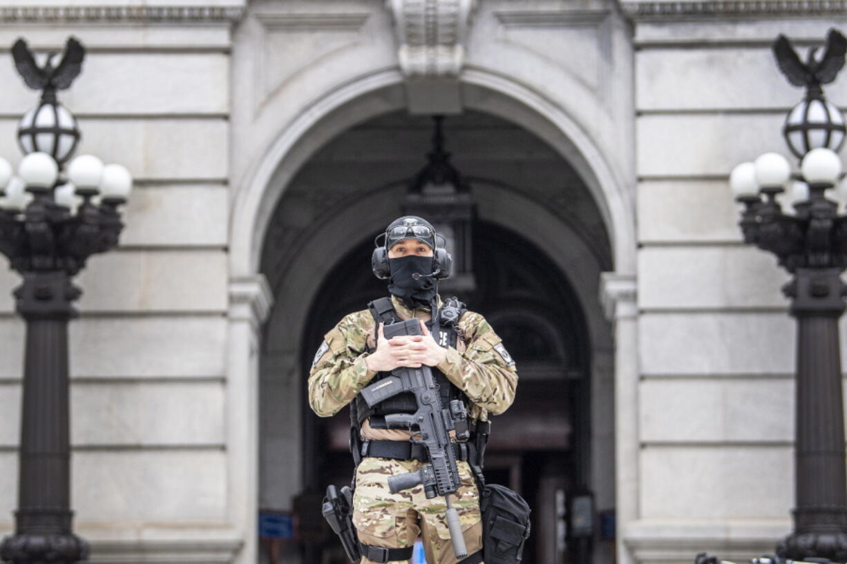 A member of the Pennsylvania Capitol Police guards the entrance to the Pennsylvania Capitol Complex in Harrisburg, Pa. Wednesday, Jan. 13, 2021. State capitols across the country are under heightened security after the siege of the U.S. Capitol last week.  (Jose F.