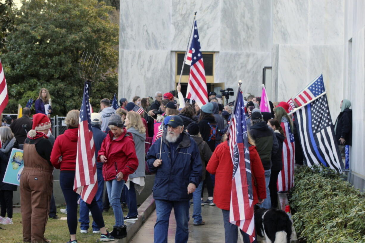 FILE - In this Dec. 21, 2020, file photo, pro-Trump and anti-mask demonstrators hold a rally outside the Oregon State Capitol as legislators meet for an emergency session in Salem, Ore. During the protest Republican lawmaker, Rep. Mike Nearman, physically opened the Capitol&#039;s door -- letting protesters, who clashed with police, gain access to the building. There have been calls for Nearman to resign ahead of the upcoming 2021 Legislative session that begins Tuesday, Jan. 19, 2021.