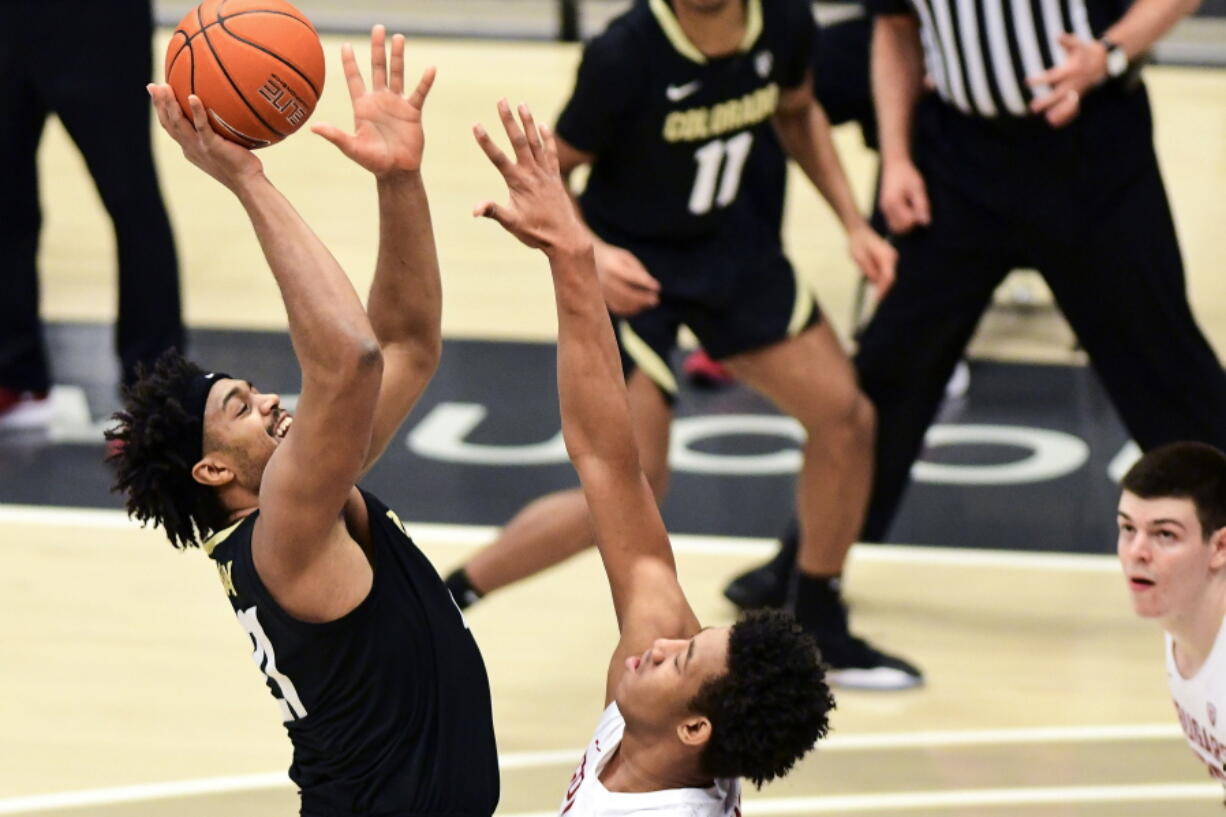 Colorado forward Evan Battey, left, shoots as Washington State center Dishon Jackson, center, defends during the first half of an NCAA college basketball game Saturday, Jan. 23, 2021, in Pullman, Wash.