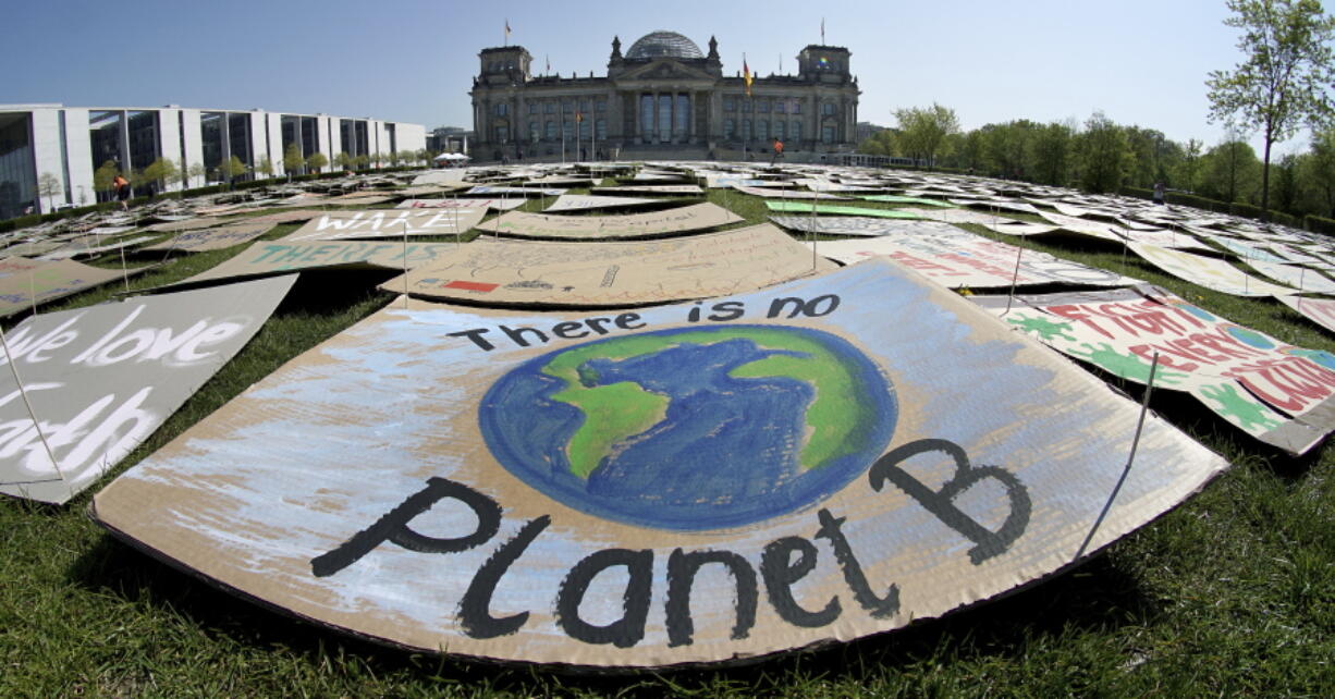 In this Friday, April 24, 2020 file photo, activists place thousands of protest placards in front of the Reichstag building, home of the german federal parliament, Bundestag, during a protest rally of the &#039;Fridays for Future&#039; movement in Berlin, Germany. World leaders breathed an audible sigh of relief that the United States under President Joe Biden is rejoining the global effort to curb climate change, a cause that his predecessor had shunned.