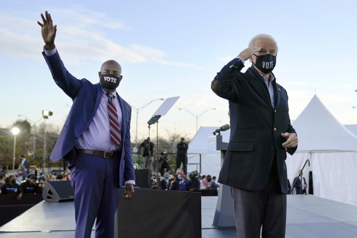 President-elect Joe Biden, right, campaigns Jan. 4 for Senate candidates Raphael Warnock, left, and Jon Ossoff, not pictured, in Atlanta.