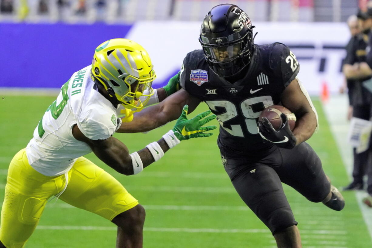 Iowa State running back Breece Hall (28) is hit by Oregon cornerback DJ James during the first half of the Fiesta Bowl NCAA college football game, Saturday, Jan. 2, 2021, in Glendale, Ariz.