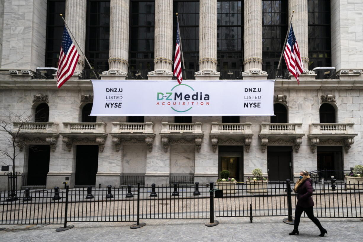 Pedestrians pass the New York Stock Exchange, Wednesday, Jan. 27, 2021, in New York.  Stocks are climbing back in the early going on Wall Street Thursday, a day after the market took its biggest one-day loss since October.