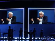 FILE - In this May 29, 2020 file photo, images of Ravi Zacharias are displayed in the Passion City Church during a memorial service for him in Atlanta. A posthumous sex scandal involving  Zacharias, who founded the Ravi Zacharias International Ministries has placed the global organization in a wrenching predicament.