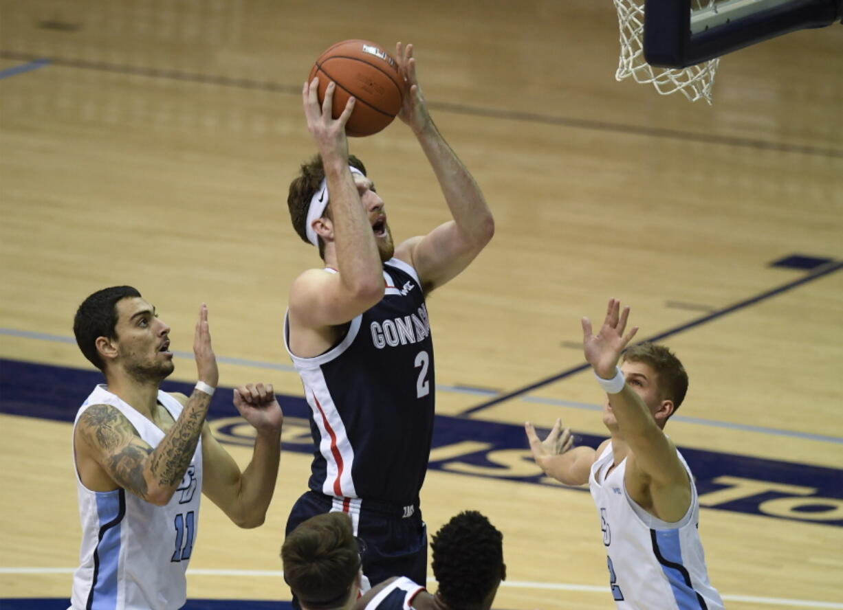 Gonzaga forward Drew Timme (2), center, shoots past San Diego forward Yavuz Gultekin (11), left, and guard Joey Calcaterra (2) during the first half of an NCAA college basketball game Thursday, Jan. 28, 2021, in San Diego.