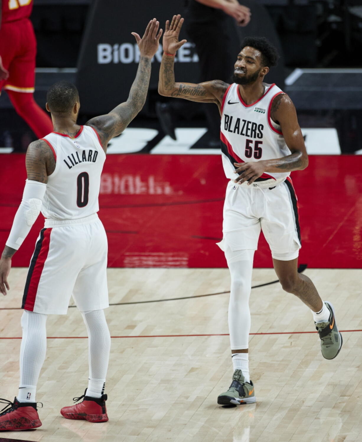 Portland Trail Blazers forward Derrick Jones Jr., right, high-fives guard Damian Lillard after Jones scored against the Atlanta Hawks during the second half of an NBA basketball game in Portland, Ore., Saturday, Jan. 16, 2021.