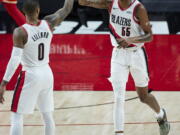 Portland Trail Blazers forward Derrick Jones Jr., right, high-fives guard Damian Lillard after Jones scored against the Atlanta Hawks during the second half of an NBA basketball game in Portland, Ore., Saturday, Jan. 16, 2021.