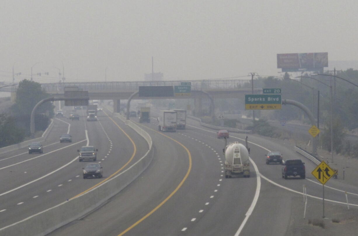 FILE - In this Wednesday, Aug. 19, 2020. file photo, smoke from California wildfires up to 200 miles away obscures the view of traffic traveling on Interstate 80, looking west in Sparks, Nev. Local schools canceled all outdoor activities as the air quality index approached the &quot;very unhealthy&quot; category for the general population Wednesday afternoon.