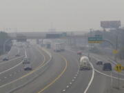 FILE - In this Wednesday, Aug. 19, 2020. file photo, smoke from California wildfires up to 200 miles away obscures the view of traffic traveling on Interstate 80, looking west in Sparks, Nev. Local schools canceled all outdoor activities as the air quality index approached the &quot;very unhealthy&quot; category for the general population Wednesday afternoon.