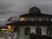 Hot lava runs down from the crater of Mount Merapi, partially seen behind a mosque in Sleman, Indonesia, late Tuesday, Jan. 26, 2021. The country&#039;s most active volcano erupted Wednesday with a river of lava and searing gas clouds flowing 1,500 meters (4,900 feet) down its slopes.