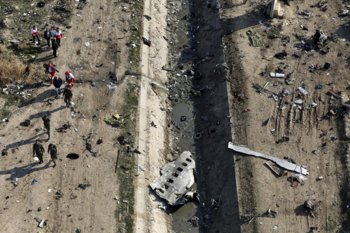 FILE - In this Jan. 8, 2020, file photo, rescue workers search the scene where an Ukrainian plane was shot down in Shahedshahr, southwest of Tehran, Iran. More questions than answers remain about the disaster that killed 176 people on board the Ukrainian jetliner, a year after Iran&#039;s military mistakenly downed the plane with surface-to-air missiles. Officials in Canada, which was home to many of the passengers on the doomed plane, and other affected countries have raised concerns about the lack of transparency and accountability in Iran&#039;s investigation of its own military.