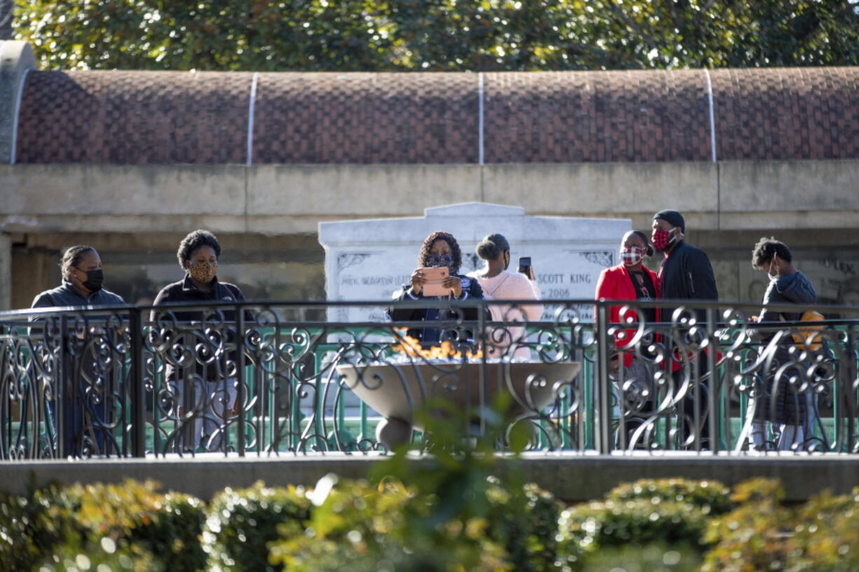 People visit the eternal flame at the tomb of Rev. Martin Luther King Jr. and his wife Coretta Scott King on Monday, Jan. 18, 2021, to celebrate the Martin Luther King Jr. holiday, in Atlanta.