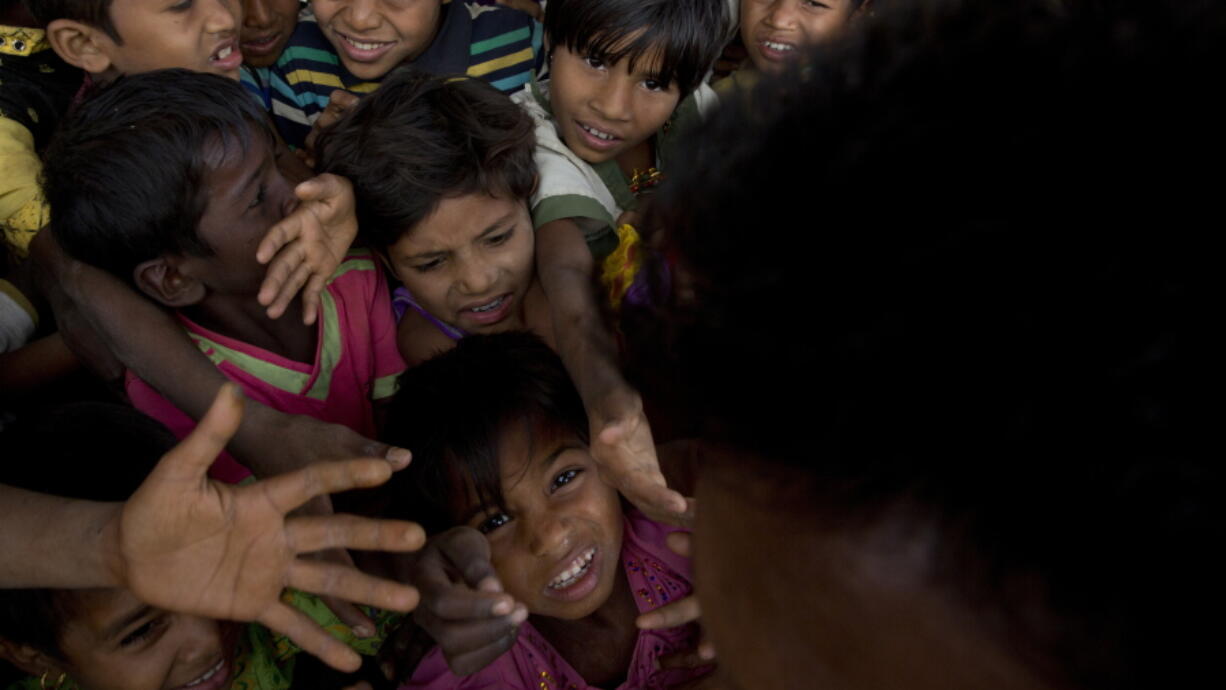 In this Wednesday, Jan. 17, 2018, file photo, Rohingya refugee children push each other to receive a packet of Khichdi, made from rice and lentils, at a food distribution centre in Balukhali refugee camp near Cox&#039;s Bazar, Bangladesh. United Nations agencies are warning that more than 350 million people in the Asia-Pacific are going hungry as the coronavirus pandemic destroys jobs and pushes food prices higher.