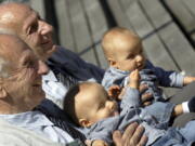 Identical twins Alf, left, and Sven Fehnhanhn, left background, 79, from Kassel, pose along with 7-month-old Luis Carl, foreground, and Albert Frank Millgramm, right background, during a twins&#039; meeting in Berlin. According to research published recently, identical twins are not exactly the same genetically.