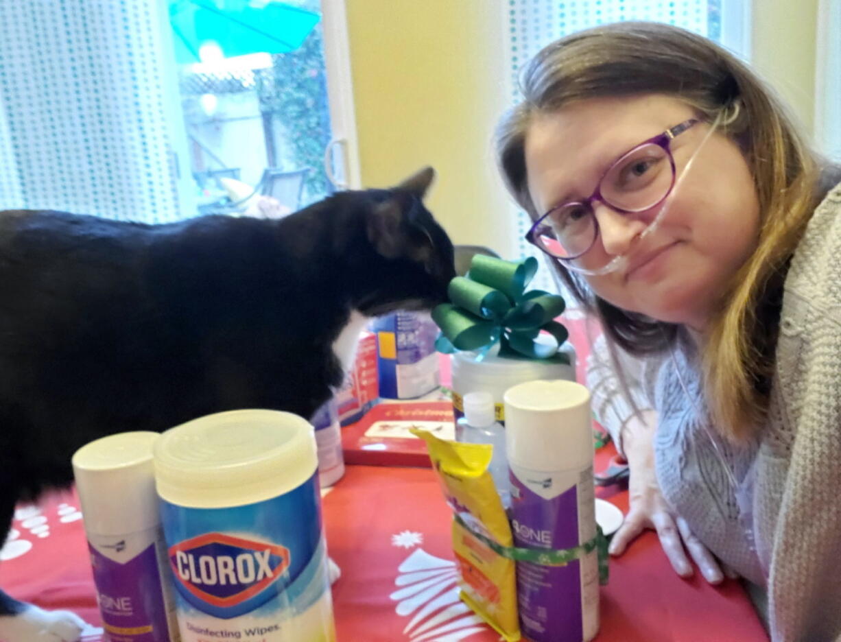 In this photo provided by Corinna Dewar, Dewar poses for a selfie while preparing care packages of sanitizing products to give to friends, family and neighbors at her home in Carmichael, Calif., on Dec. 30, 2020. In past years Dewar and her husband have made and delivered cookies, but this year they decided due to the pandemic that giving necessities like cleaning supplies would be safe and practical.