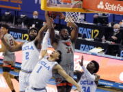 Oregon State forward Rodrigue Andela (34) grabs rebound over UCLA forward Cody Riley (2) and guard Jules Bernard (1) during the first half of an NCAA college basketball game Saturday, Jan. 30, 2021, in Los Angeles.