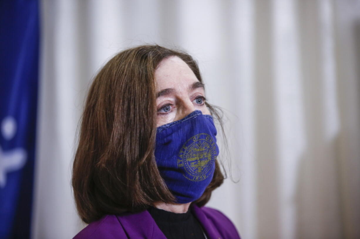 FILE - In this Jan. 13, 2021, file photo, Oregon Gov. Kate Brown visits the Marion County and Salem Health COVID-19 vaccination clinic in Salem, Ore. On Thursday, Jan. 21, 2021, the Democrat delivered her State of the State address, reflecting on the challenges Oregonians have faced in the last year, the pandemic, protests, wildfires and outlined her goals for the future, focusing on racial equity, ensuring children return to school, mitigating wildfire danger and expanding health care access.