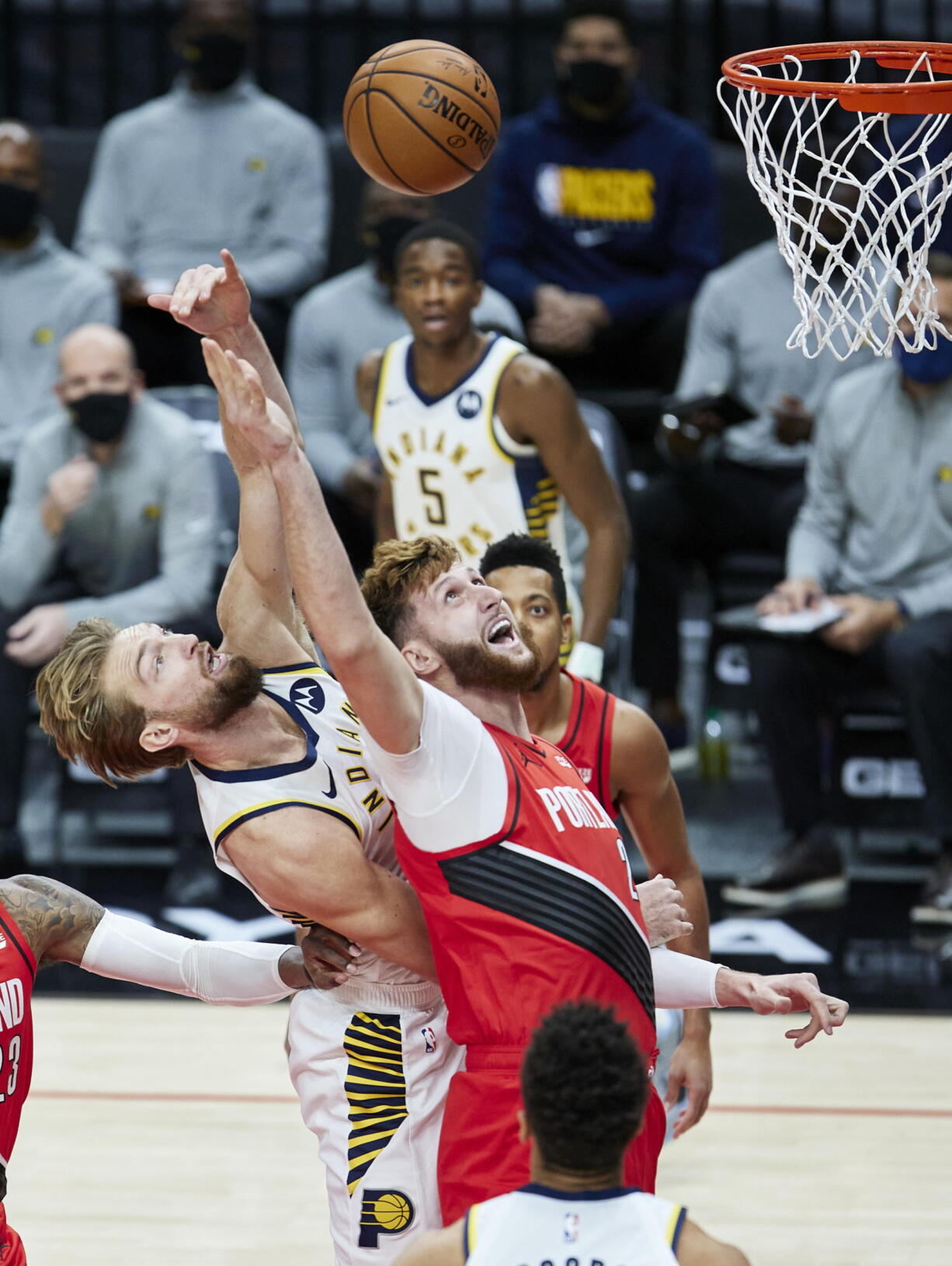 Indiana Pacers forward Domantas Sabonis, left, and Portland Trail Blazers center Jusuf Nurkic reach for a rebound during the first half of an NBA basketball game in Portland, Ore., Thursday, Jan. 14, 2021.