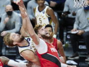 Indiana Pacers forward Domantas Sabonis, left, and Portland Trail Blazers center Jusuf Nurkic reach for a rebound during the first half of an NBA basketball game in Portland, Ore., Thursday, Jan. 14, 2021.