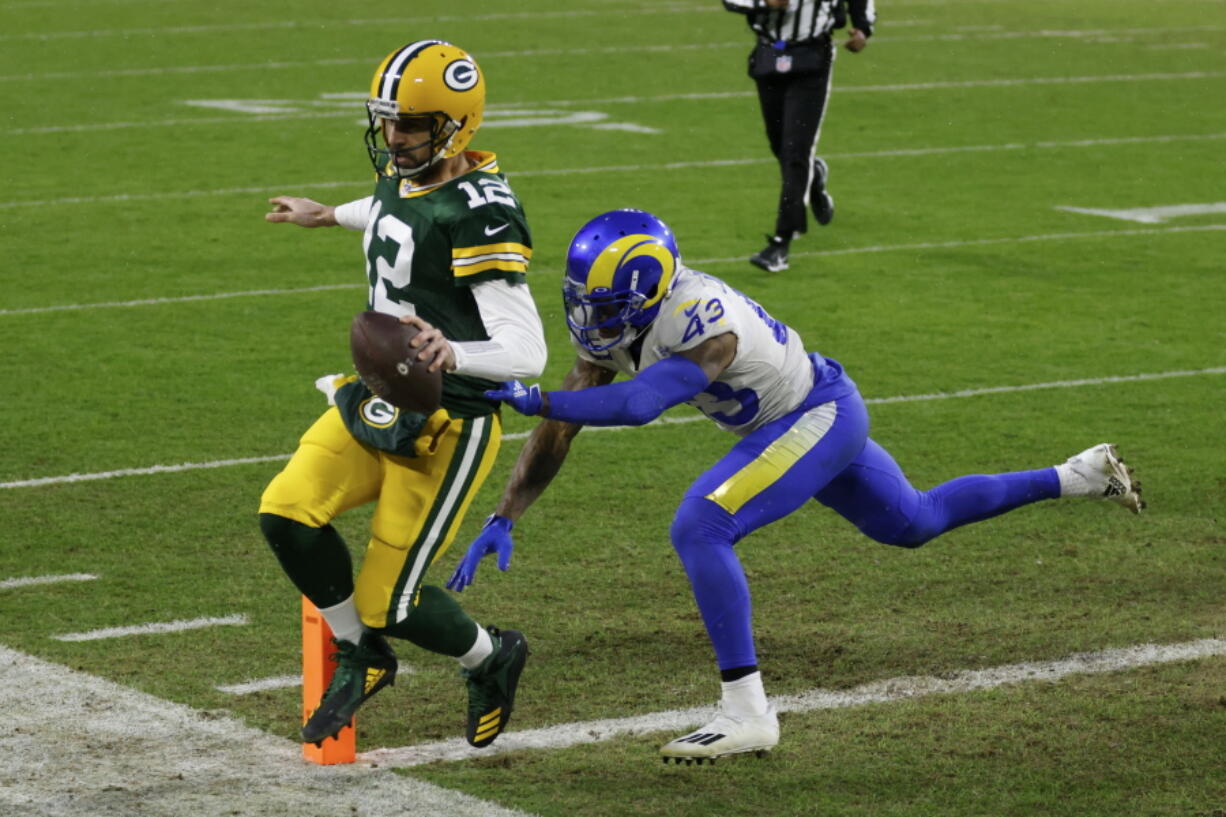 Green Bay Packers quarterback Aaron Rodgers scores on a one-yard touchdown run past Los Angeles Rams&#039; John Johnson during the first half of an NFL divisional playoff football game, Saturday, Jan. 16, 2021, in Green Bay, Wis.