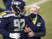 Seattle Seahawks head coach Pete Carroll, right, walks off the field with defensive tackle Bryan Mone after the team lost to the Los Angeles Rams in an NFL wild-card playoff football game, Saturday in Seattle. (Ted S.