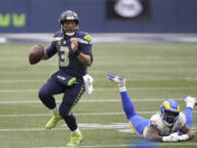 Seattle Seahawks quarterback Russell Wilson (3) scrambles away from Los Angeles Rams outside linebacker Leonard Floyd during the second half of an NFL wild-card playoff football game, Saturday, Jan. 9, 2021, in Seattle. (AP Photo/Ted S.