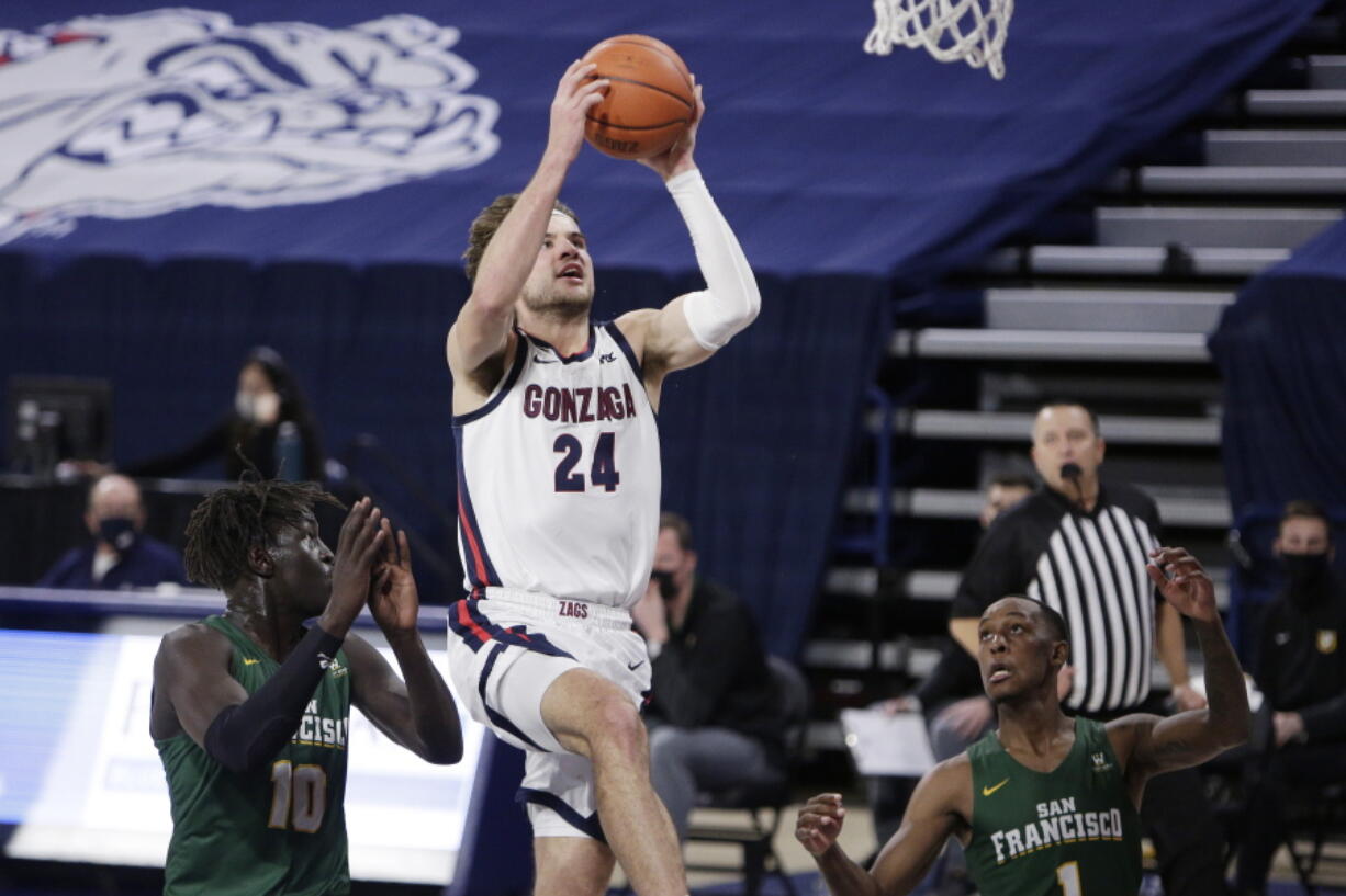 Gonzaga forward Corey Kispert (24) shoots between San Francisco forward Josh Kunen (10) and guard Jamaree Bouyea (1) during the first half of an NCAA college basketball game in Spokane, Wash., Saturday, Jan. 2, 2021.