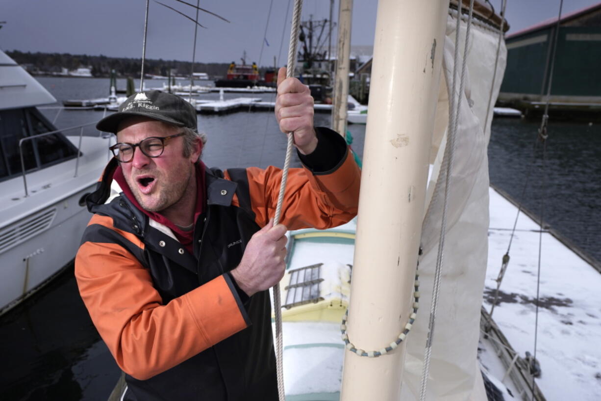 Bennett Konesni sings a sea shanty while raising a sail on his ketch, Thursday, Jan. 28, 2021, in Belfast, Maine. Konesni started singing sea shanties aboard a schooner in Penobscot Bay and has since traveled the world studying work songs. The app TikTok helped sea shanties surge into the mainstream. (AP Photo/Robert F.