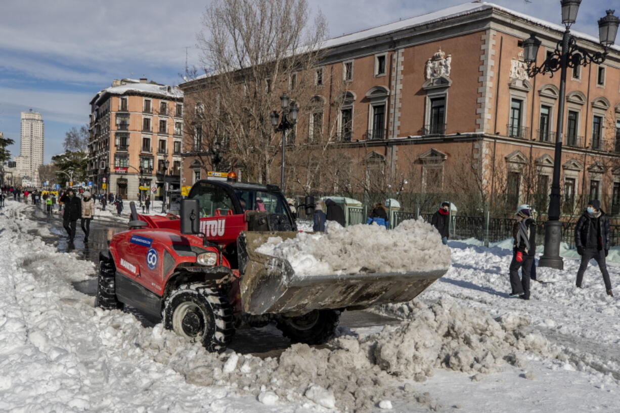 A plough clears snow in downtown Madrid, Spain, Sunday, Jan. 10, 2021. A large part of central Spain including the capital of Madrid are slowly clearing snow after the country&#039;s worst snowstorm in recent memory.