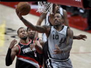 San Antonio Spurs forward DeMar DeRozan, right, drives to the basket on Portland Trail Blazers guard Rodney Hood, right, during the second half of an NBA basketball game in Portland, Ore., Monday, Jan. 18, 2021.