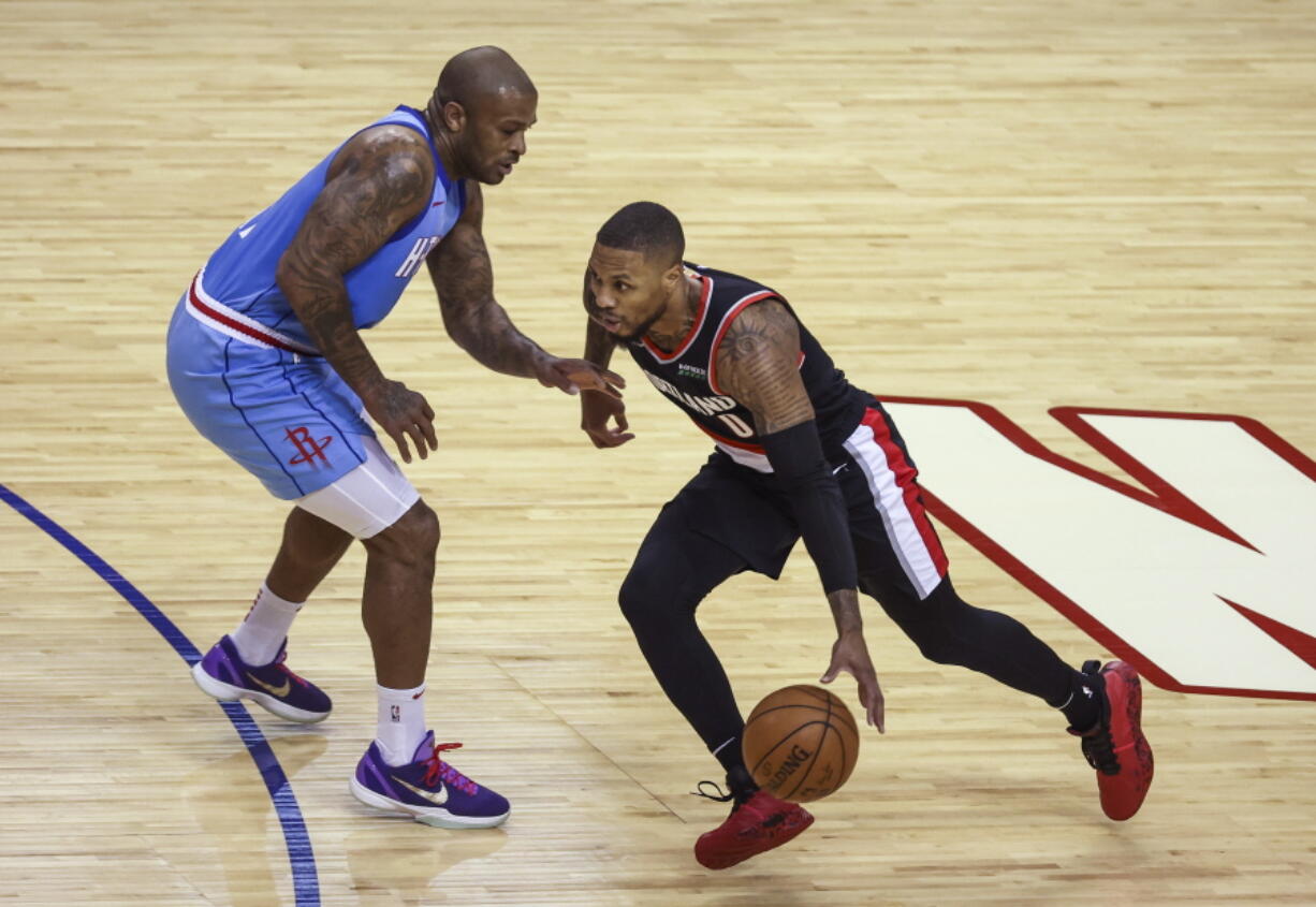 Portland Trail Blazers guard Damian Lillard (0) drives against Houston Rockets forward P.J. Tucker (17) during the first quarterof an NBA basketball game Thursday, Jan. 28, 2021, in Houston.