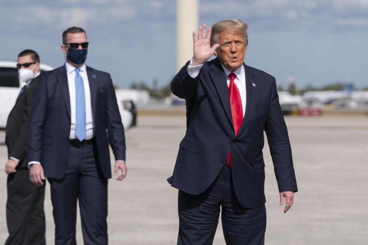 Former President Donald Trump waves to the members of the media on arrival at Palm Beach International Airport in West Palm Beach, Fla., Wednesday, Jan. 20, 2021.