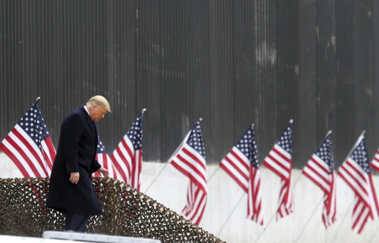 President Donald Trump walks down the steps before a speech near a section of the U.S.-Mexico border wall, Tuesday, Jan. 12, 2021, in Alamo, Texas.