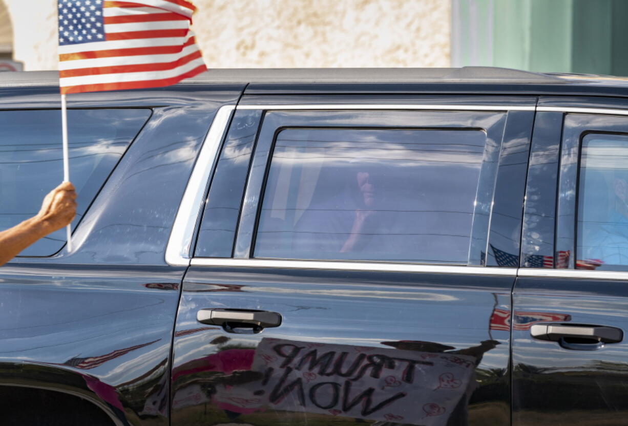 Former President Donald Trump passes supporters while traveling in his motorcade in West Palm Beach, Fla., on Wednesday, Jan. 27, 2021, on his way to Mar-a-Lago in Palm Beach.