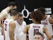 Washington State coach Kyle Smith, center, talks to the team during a break in play in the second half of an NCAA college basketball game against Utah in Pullman, Wash., Thursday, Jan. 21, 2021.